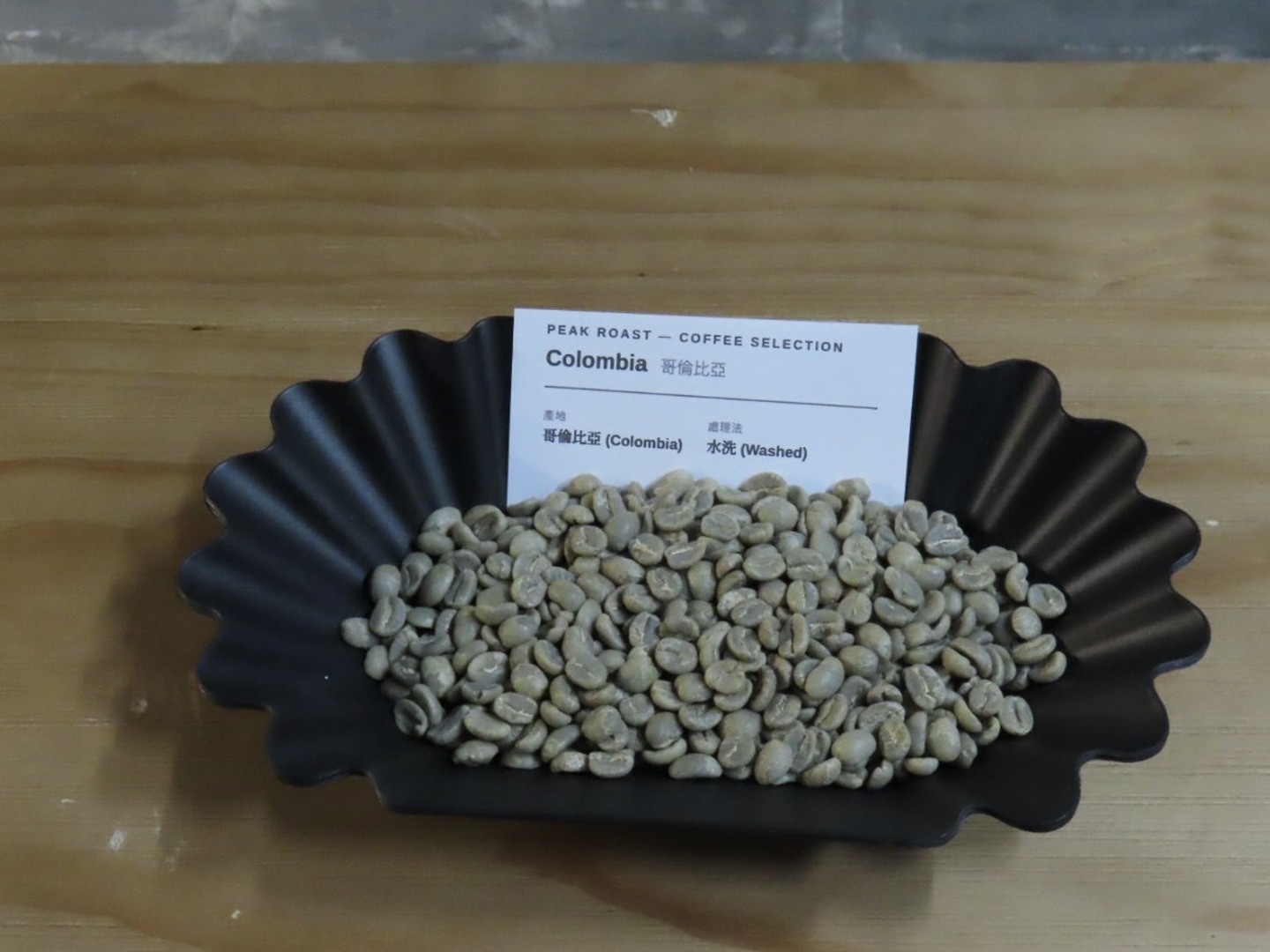 Colombia Washed — green coffee on a black fluted tray